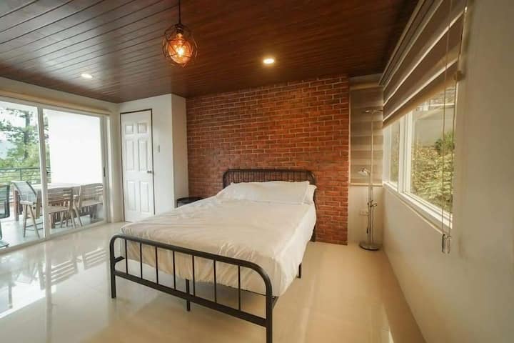 חדר השינה בקומה העליונה כולל מיטת קווין סייז וגישה למרפסת.