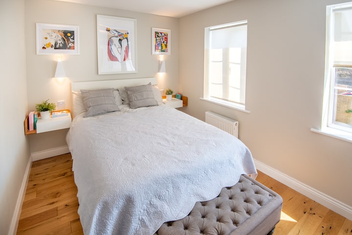 First floor master bedroom with a double bed, there are two windows facing the garden