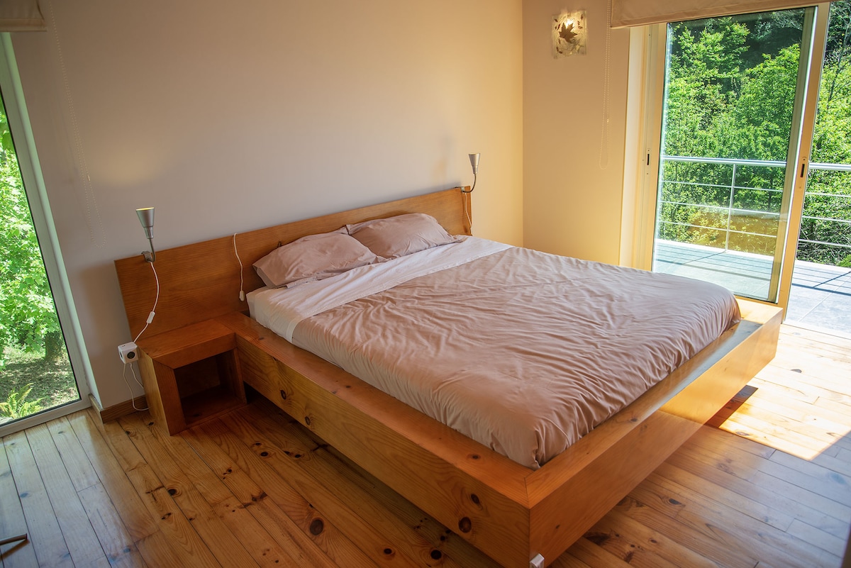 Bed with a 1,6 x 2 m orthopaedic mattress, window with a view to one of our waterfalls, and french windows to the balcony with a panoramic view over the forest surroundings.
