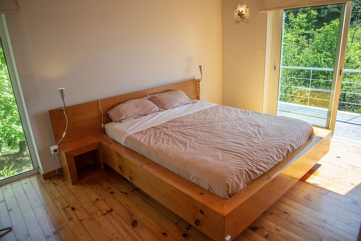 Bed with a 1,6 x 2 m orthopaedic mattress, window with a view to one of our waterfalls, and french windows to the balcony with a panoramic view over the forest surroundings.