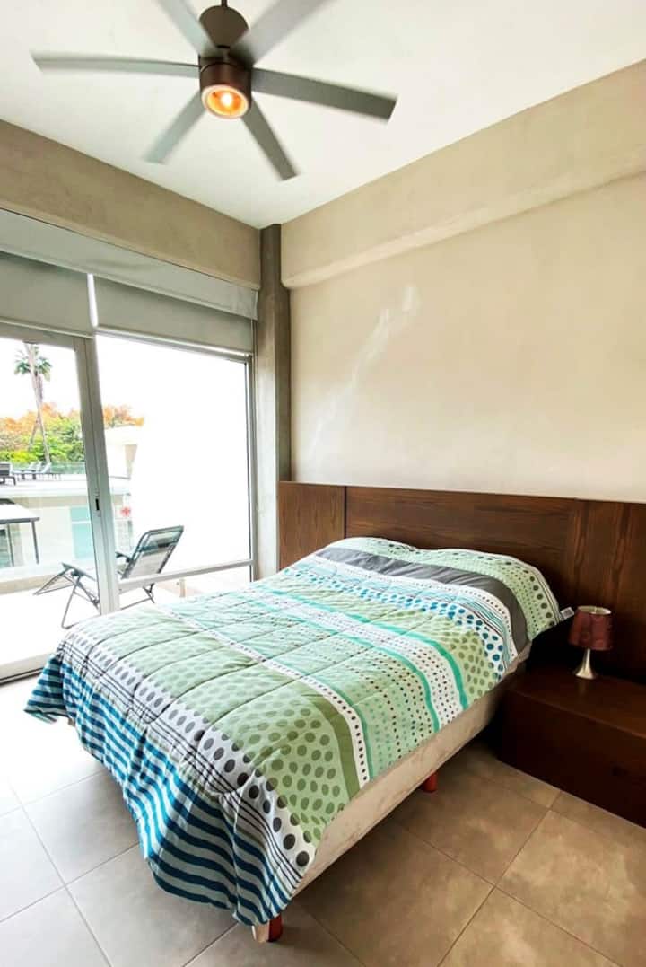 Cuarto principal con TV, AC y ventilador de techo