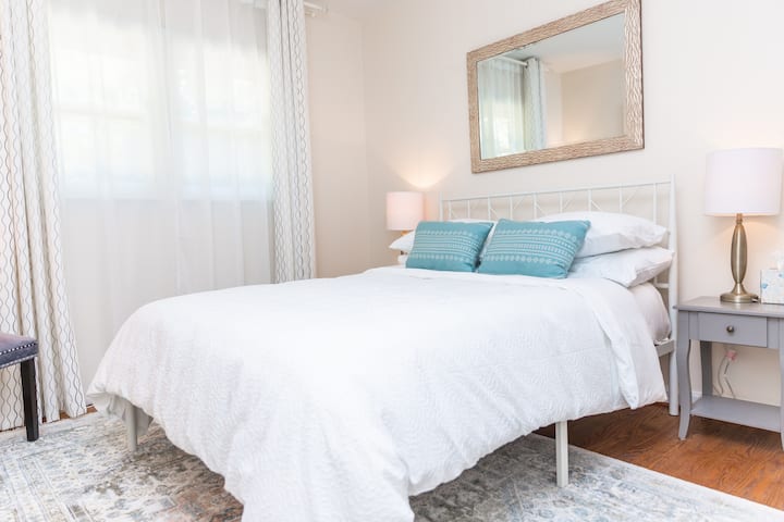 Chumba cha kulala chenye starehe na kinachovutia chenye kitanda kamili, mwanga laini na mapambo ya kifahari katika toni za kutuliza za kawaida. 