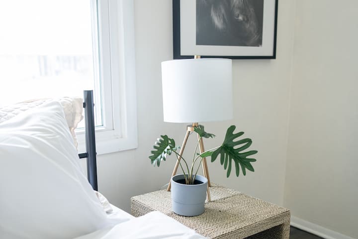 אור שמש יפהפה זורם דרך החלונות, מה שהופך את חדר השינה הזה לבהיר ומשמח. 