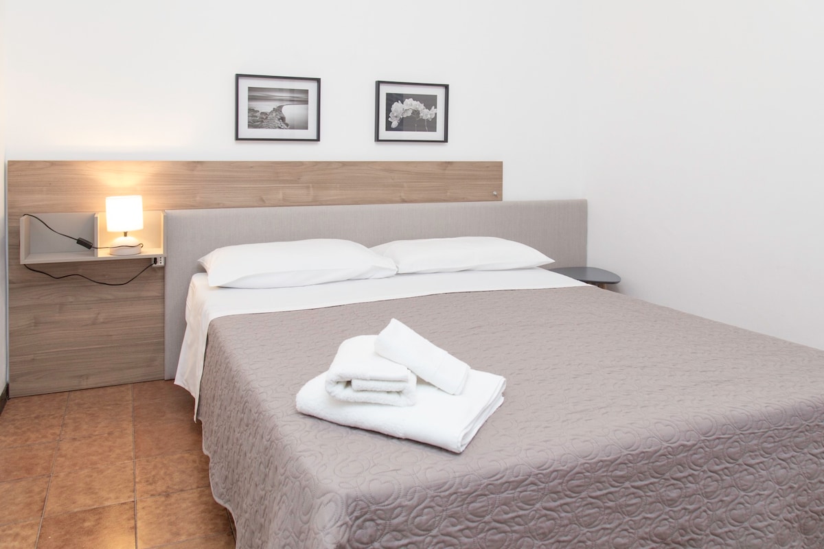 ห้องนอนคู่ที่สว่างและอบอุ่นพร้อมเตียงควีนไซส์และระเบียงส่วนตัว