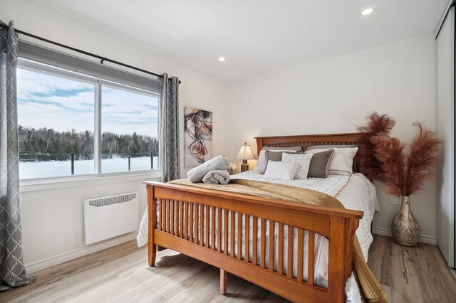 ห้องนอนหลักพร้อมวิวทะเลสาบและมู่ลี่สีเข้มในห้อง