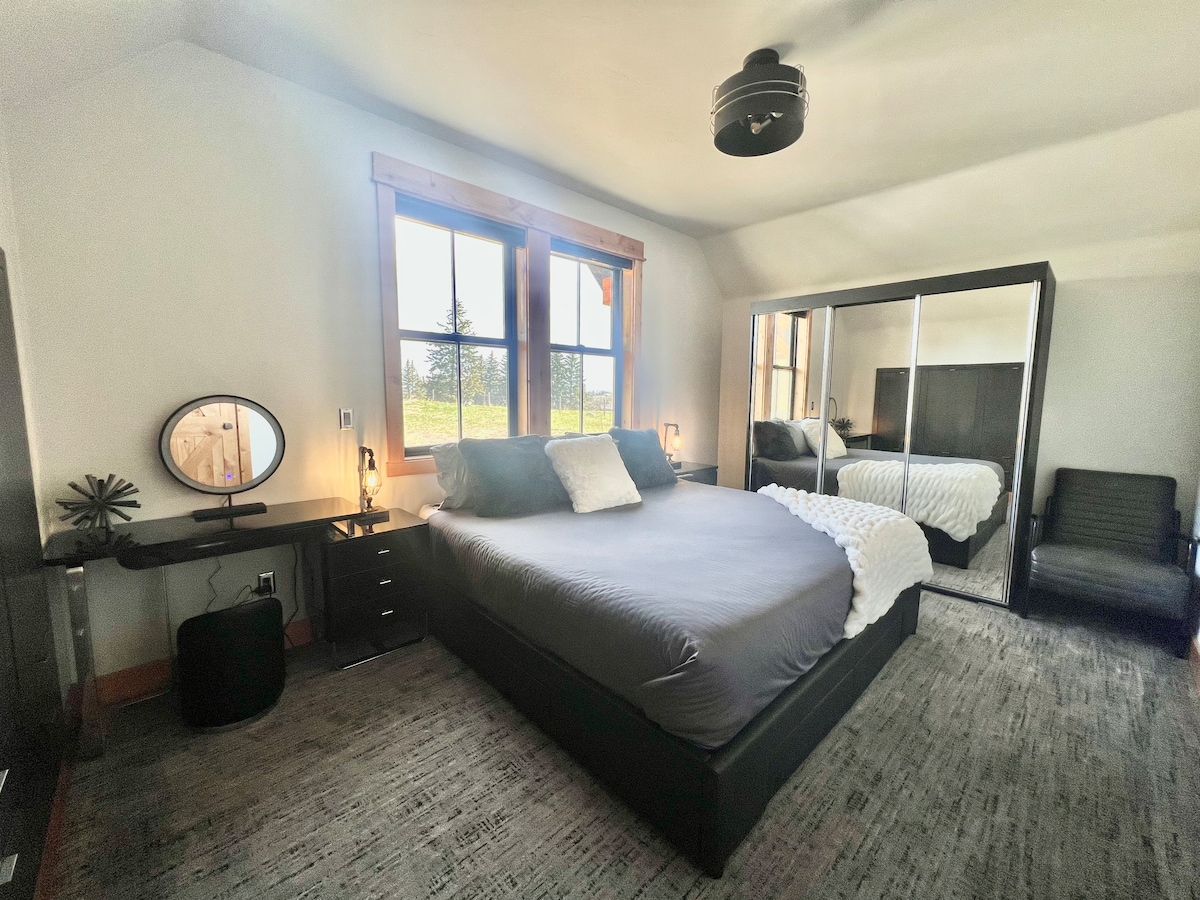 Основна спалня с двойно легло и изглед към Националния парк „Глетчер“ в далечината