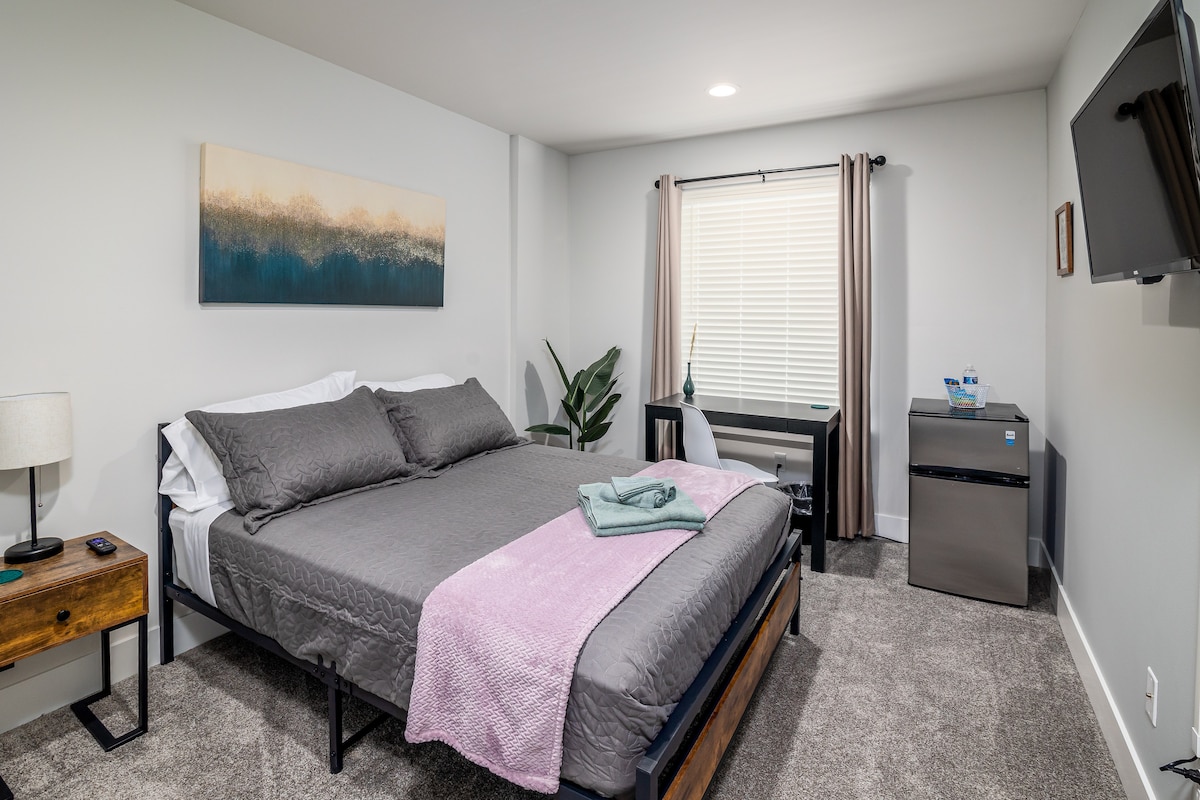 Სრული ზომის საწოლი, სამუშაო სივრცით, მინი-მაცივრით და ტელევიზორით.