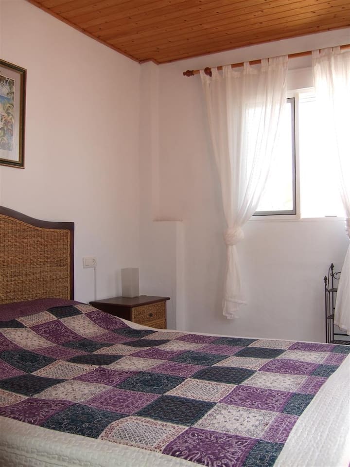 Spavaća soba na gornjem katu s bračnim krevetom, velikim ormarom i kliznim vratima na terasu