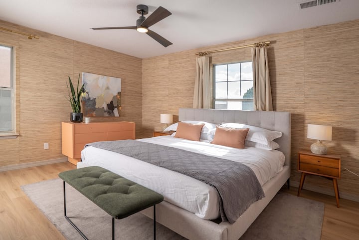 Fourth bedroom located downstairs, king bed with Helix hybrid mattress, serene decor with grass cloth wallpaper.