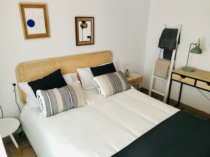 Chambre avec lit de 150 cm, bureau de travail avec flexo, armoire armoire, tables de chevet avec lampes individuelles, ventilateur de plafond et moustiquaire.