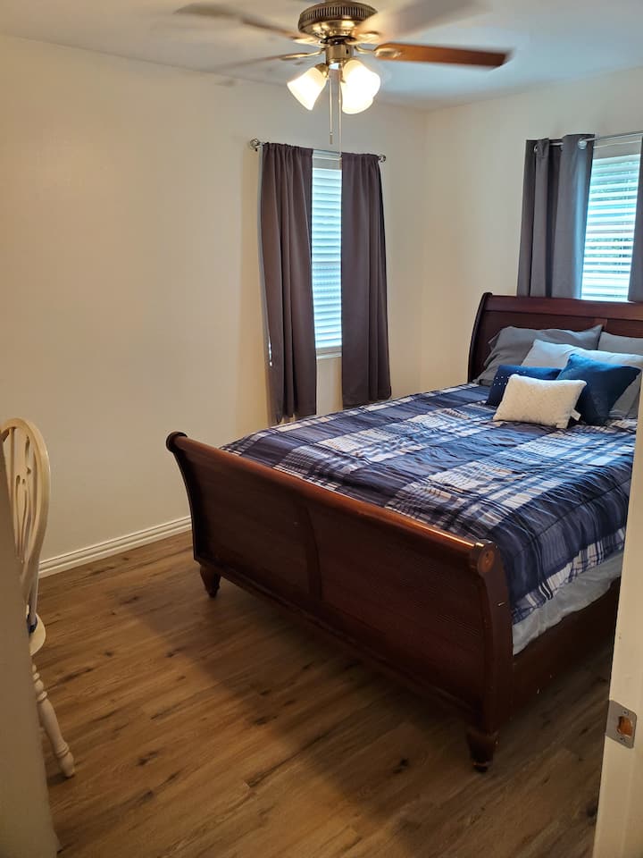La première chambre dispose d'un lit Queen et d'un espace de travail désigné.