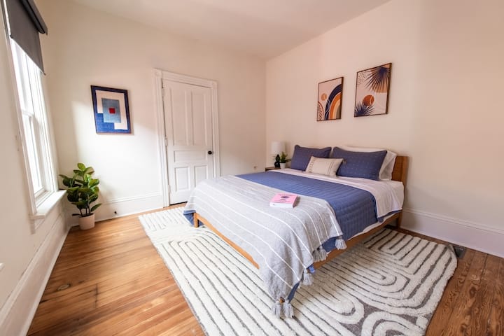 Თანამედროვე საწოლი ბალიშებით, თეთრეულით, ლამპითა და ფანჯრით