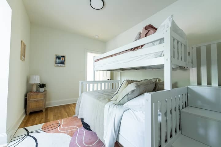 Ლოფტის ორსართულიანი საწოლი, ხალიჩა, საწოლის პატარა მაგიდა ლამპითა და მსუბუქი კედლებით