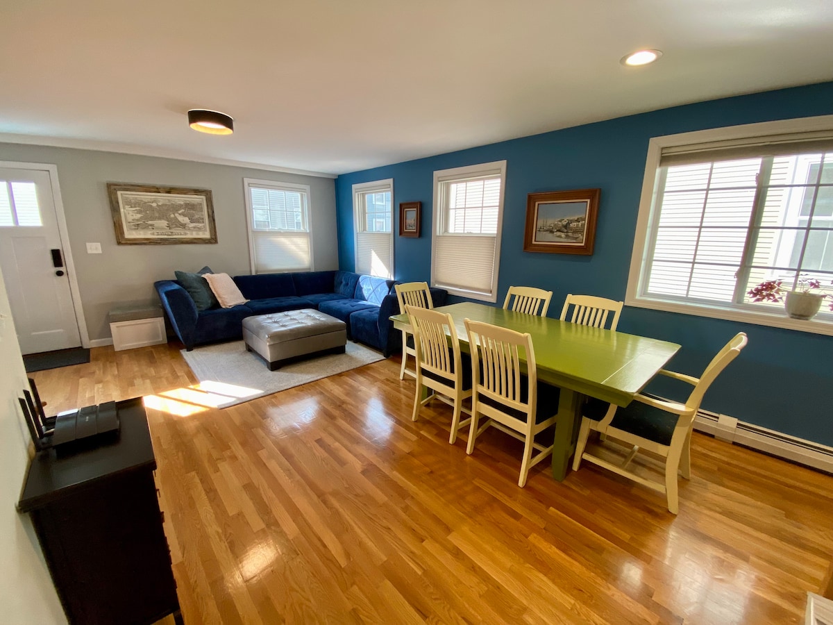 Salon/salle à manger ouverte ensoleillée. 

Un grand canapé confortable, une télévision, une table à manger pour 6 personnes et une demi-salle de bain avec buanderie complètent cet espace.