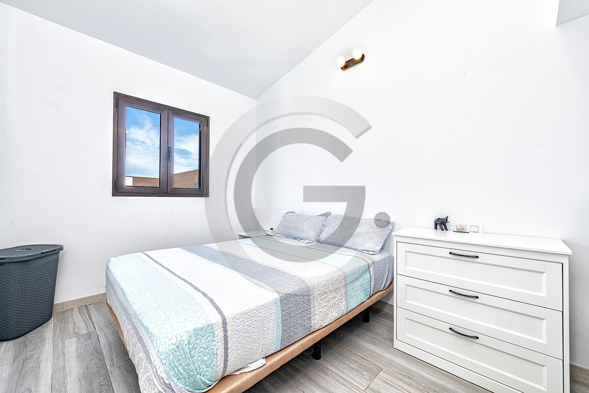 Спална соба со двоен кревет, мебел и висечка облека 