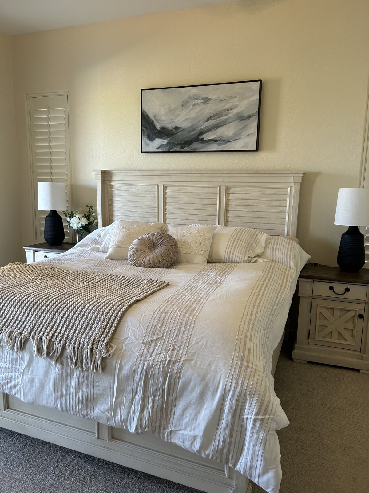 Главната спалня е светла, просторна и проектирана за комфорт. Голямо, плюшено легло с чисти спални комплекти е разположено в центъра на стаята, заобиколено от съвпадащи нощни шкафчета и меко, топло осветление.