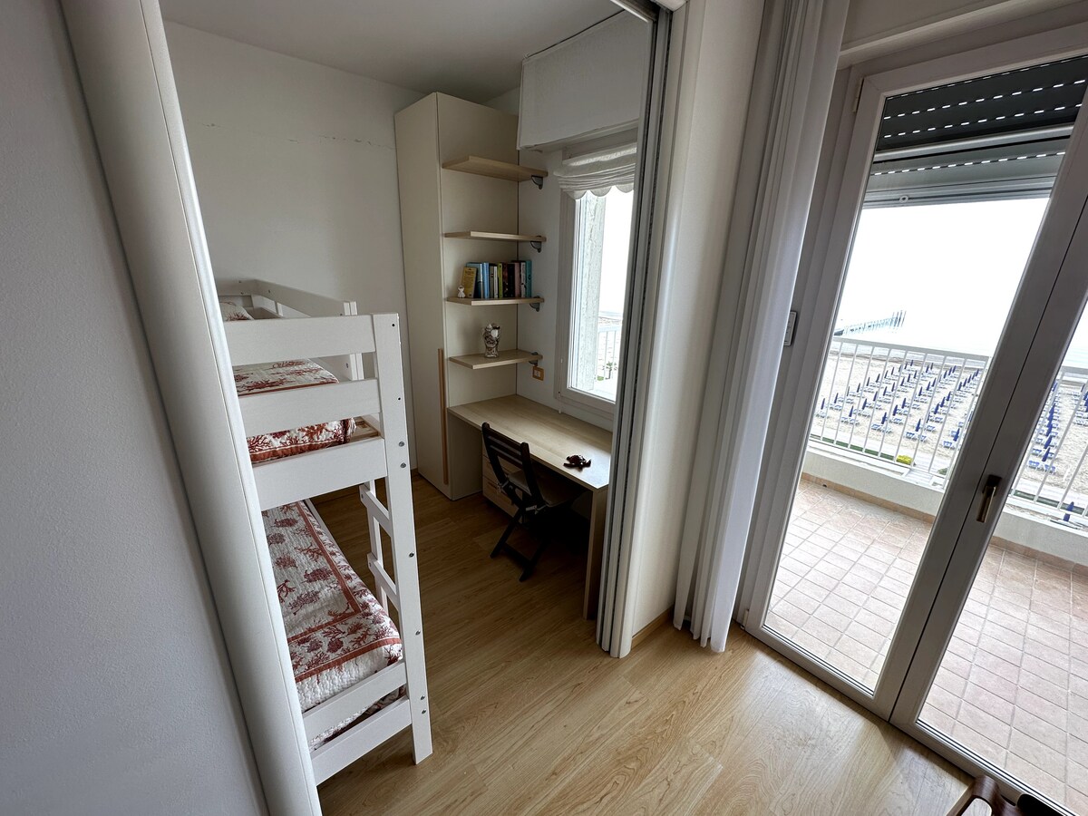 Spálňa s výhľadom, poschodová posteľ a písací stôl.