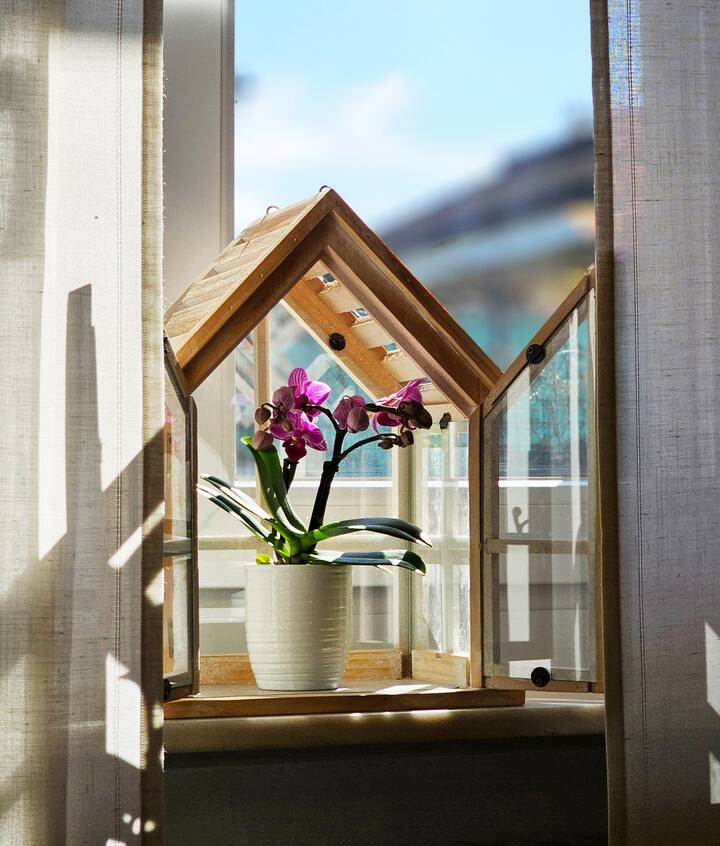 صورة مفصلة مع بيت خشبي مع مخطط أرضية في الداخل على عتبة النافذة في غرفة المعيشة