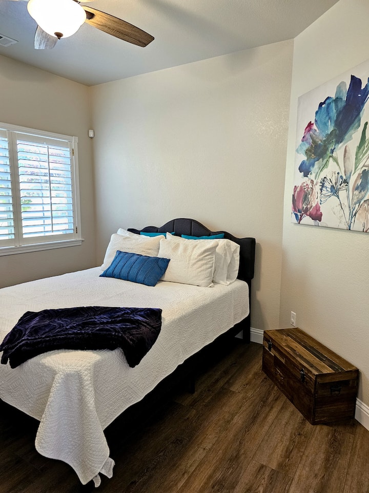 Chumba cha kulala cha kufurahisha chenye mwangaza kilicho na kitanda cha malkia. Kubwa karibu na mmiliki wa mizigo.