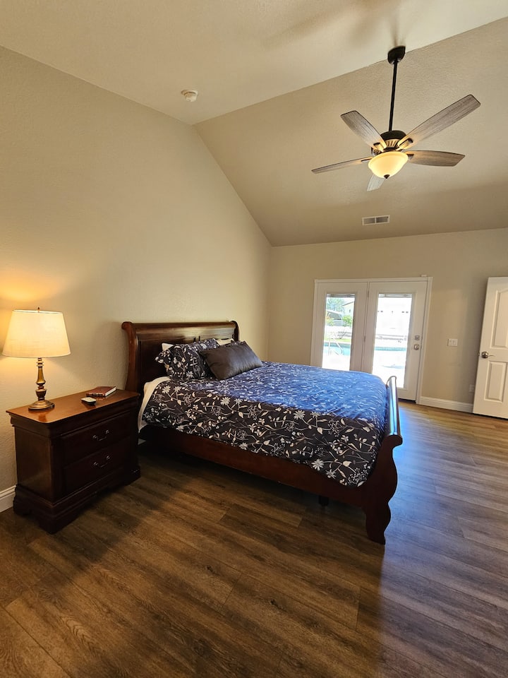 Pata starehe katika chumba hiki cha Cal-King Master Suite. Kitanda hiki kina fremu ya kitanda cha nguvu ambayo inakuwezesha kuinua kichwa au miguu yako kwa nafasi nzuri.  Mlango wa glasi unaelekea moja kwa moja kwenye bwawa. Tafadhali kumbuka milango HAINA hofu kwa watoto. Usimamizi unahitajika!