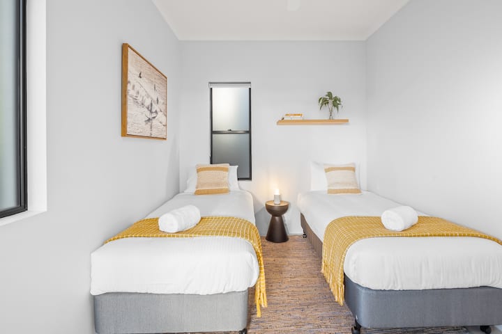 Perfect for friends or family, bedroom two offers single beds with direct balcony access and built-ins.