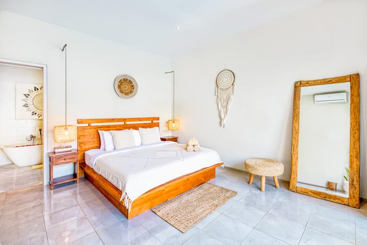 Retraite dans la chambre principale, avec un lit King Size moelleux, une climatisation et des rideaux occultants pour un sommeil réparateur.