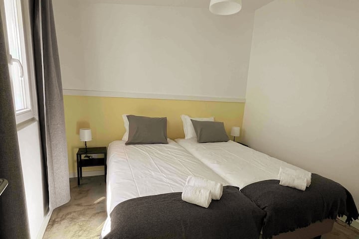 Dormitorio con dos camas individuales, ambiente sencillo y acogedor, buena iluminación natural y ropa de cama cómoda, ideal para amigos o familiares.