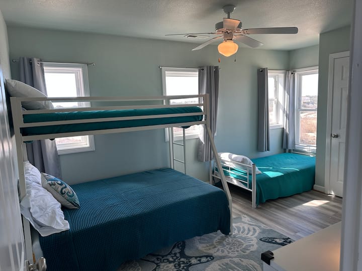 Dormitorio individual con dos camas individuales y una cama de matrimonio. Este dormitorio tiene un baño conectado Jack y Jill que comparte con Queen Beach.
