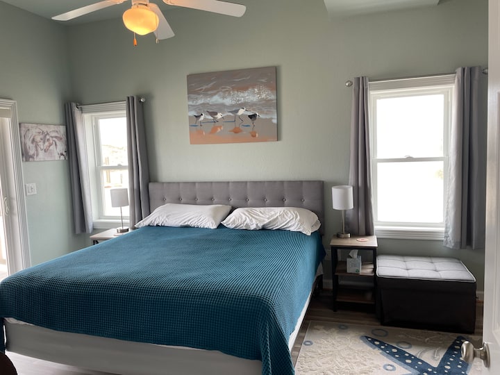 Dormitorio King Beach con una puerta corrediza de cristal (no en la foto) que conduce directamente a la terraza trasera del primer piso. Este dormitorio tiene un baño conectado y cuenta con vistas al agua desde todas las ventanas y puertas.
