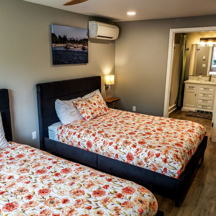 Bedroom four is at the opposite end of the house as the kitchen/living room and features 2 queen beds, 2 floating nightstands, 2 wall mounted reading lights with integrated plugins, an attached bathroom, a 55" smart TV and ductless heat/cool system.