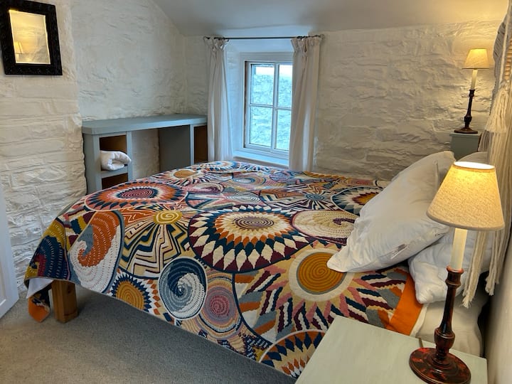 El acogedor dormitorio  tiene ventanas de doble aspecto.  