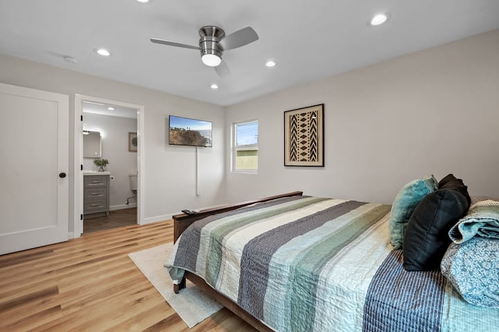 Bright and cozy bedroom with plush bedding, natural light, smart TV, and peaceful decor — a relaxing space to unwind after exploring Los Angeles or attending events at SoFi Stadium.
