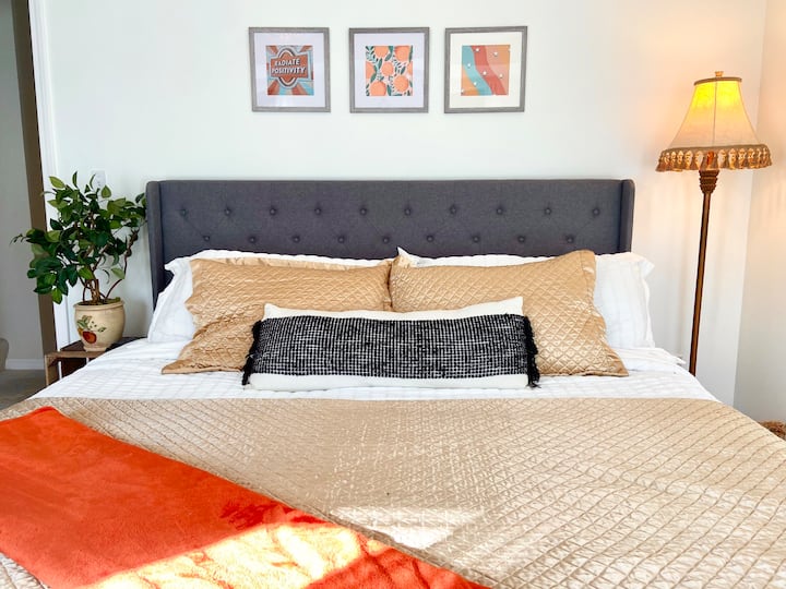 غرفة نوم بديكور بوهو تتميز بسرير كينج وتلفزيون مع روكو. تقع في مستوى الشرفة.