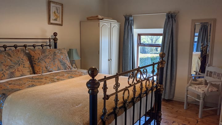 Основна спалня с двойно легло и изглед към провинцията отпред и отзад.