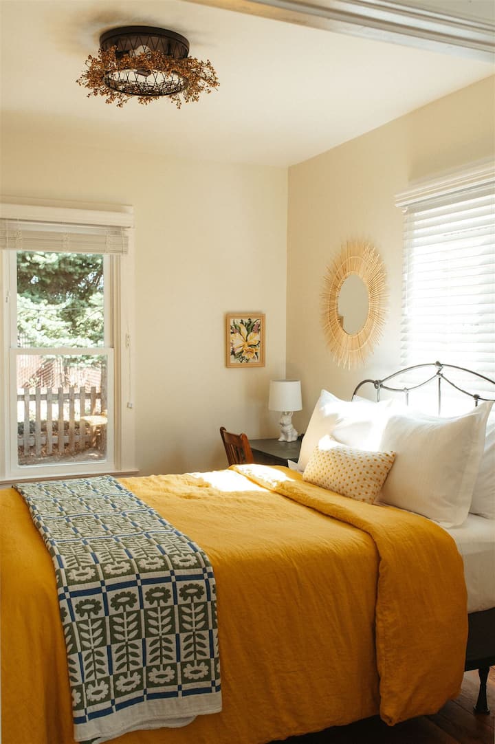 Slumber in style and comfort in the downstairs bedroom. Sink into the cozy queen bed with luxurious Schoolhouse Electric bedding, ensuring a restful night's sleep. 