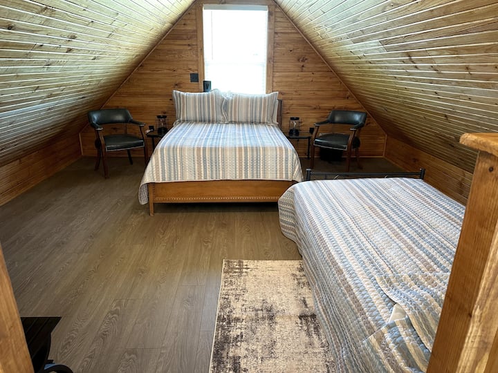 Spálňa v podkroví je 40-palcový televízor, manželská posteľ a oddelená posteľ.