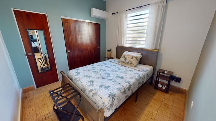 Cama Queen size con armario, reloj, espejo corporal y ropa de cama adicional.