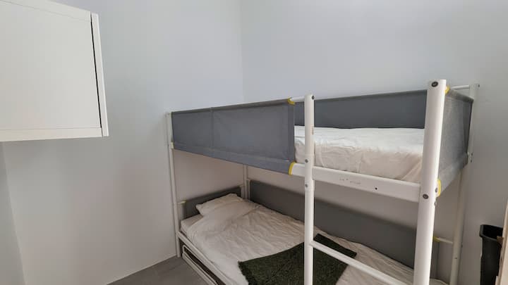 Chumba cha kulala kwa ajili ya watoto: Kitanda cha ghorofa na makabati kwa ajili ya kuhifadhi. Kitanda cha tatu kipo kwenye droo chini ya ngazi ya mwisho. 