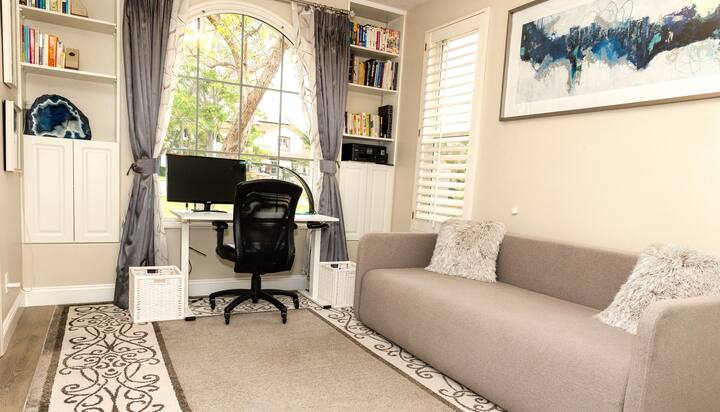 משרד עם שולחן ישיבה חשמלי וספה נפתחת בגודל מלא