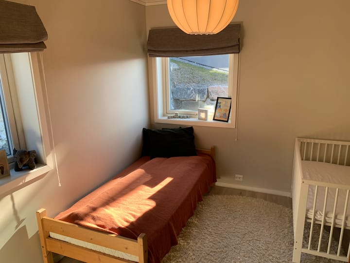 Dhomë miqsh me një krevat tek dhe krevat për bebe.