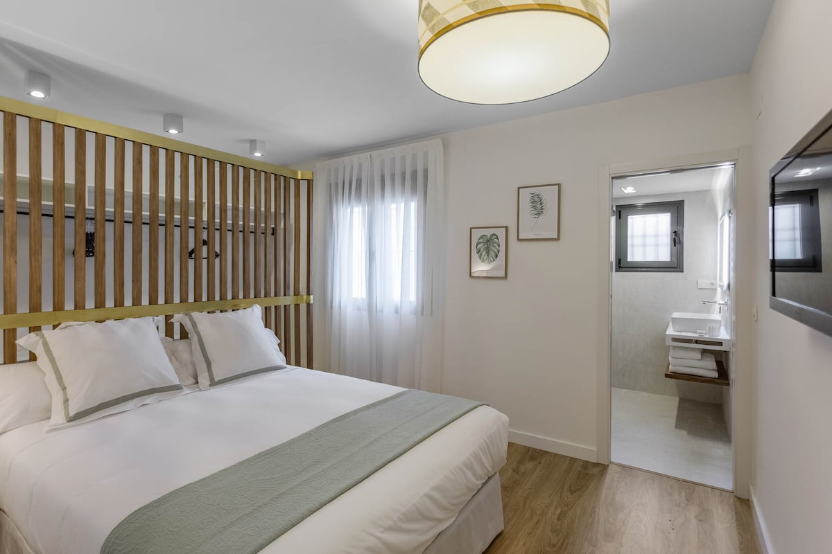 Spálňa s manželskou posteľou, šatňou a vlastnou kúpeľňou.