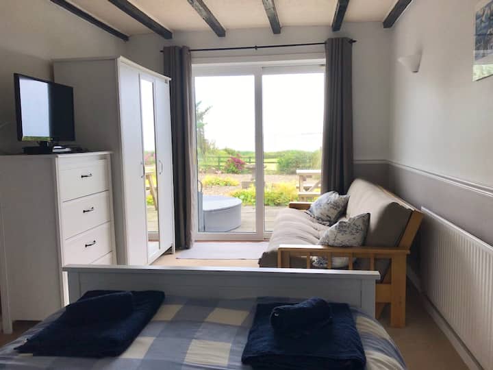 Spálňa s manželskou posteľou na prízemí sa otvára na terasu a má veľkú futonovú posteľ a manželskú posteľ.