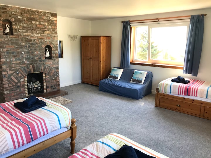 Trojlôžková spálňa na poschodí má dve veľké okná, krb (len teraz dekoratívny) a veľa priestoru.