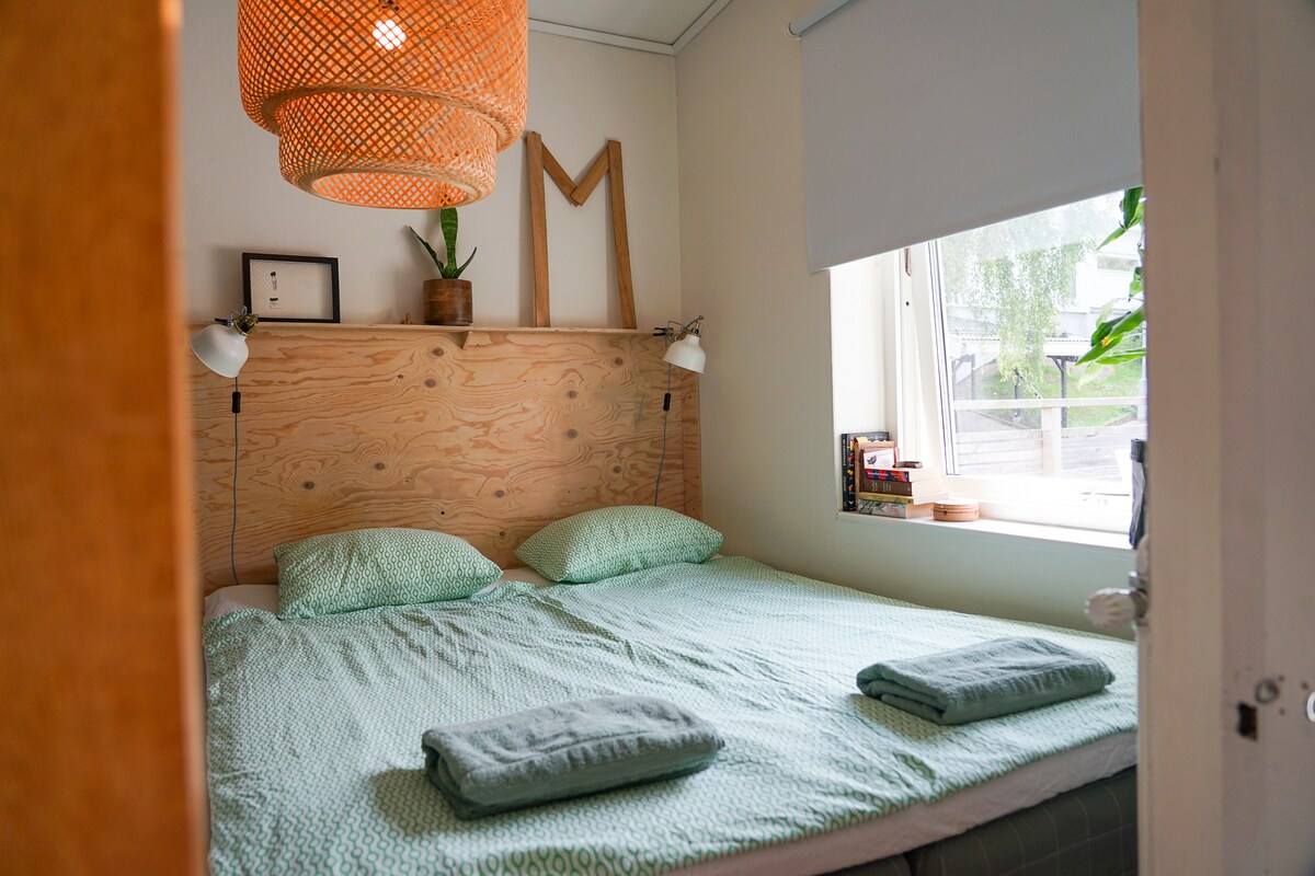 Spavaća soba s lijepim bračnim krevetom i pogledom na obližnju nadmorsku visinu.