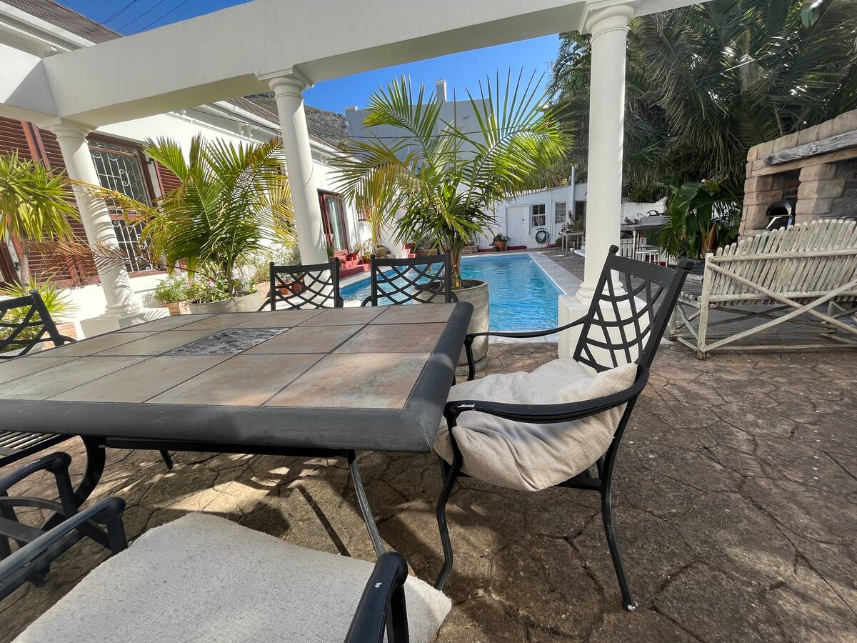 Shaded patio table beside the pool at Utopia co-living, Cape Town