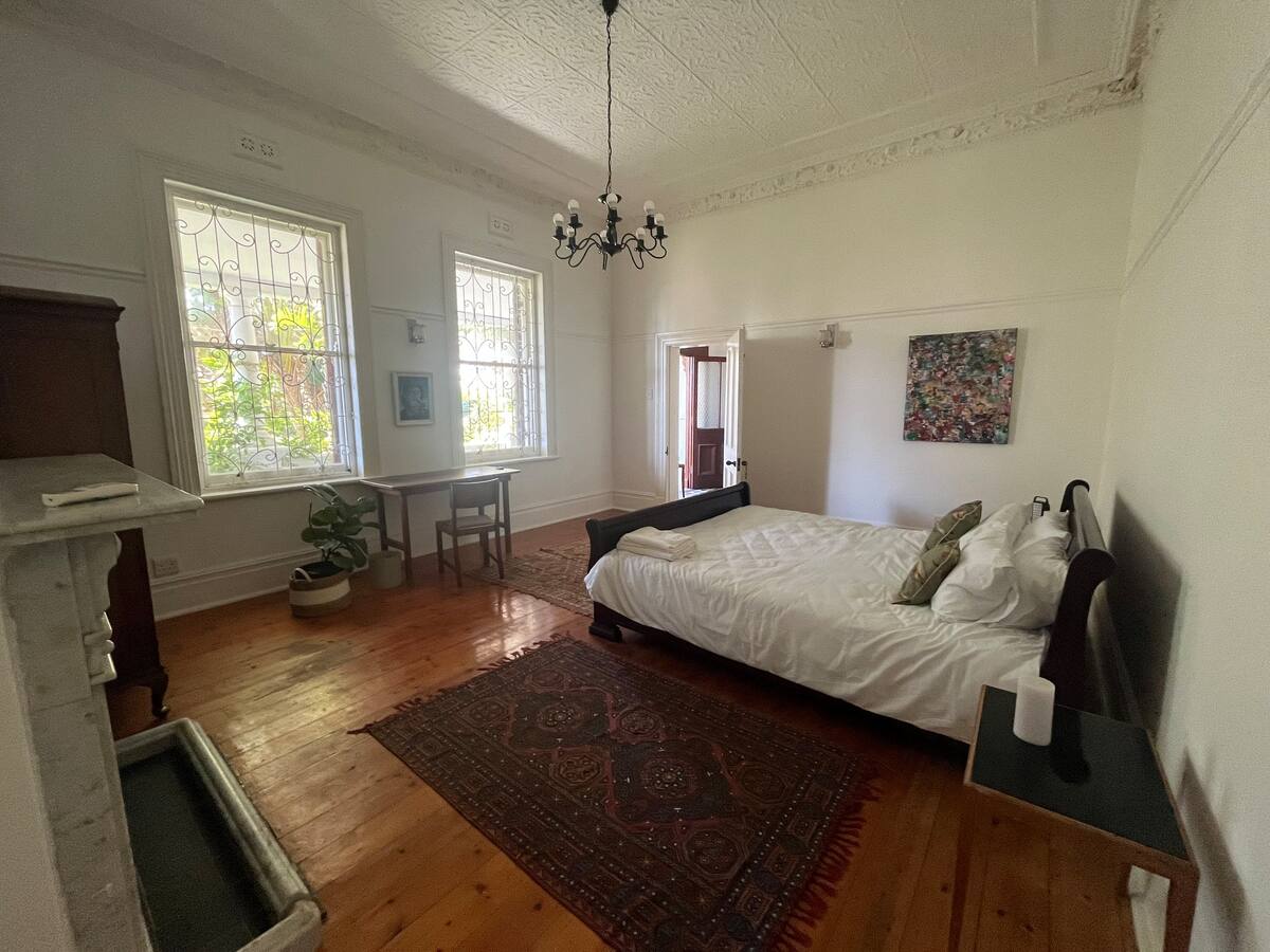 Garden king room with chandelier and garden-facing windows at Utopia co-living Cape Town