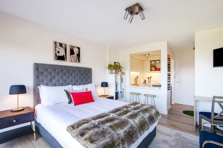 自然光が差し込むオープンプランの寝室には、柔らかなクイーンベッドが置かれ、素晴らしい景色が楽しめます。ベッドの上に取り付けられたテレビと、ゴールドの椅子がある快適なワークスペースをお楽しみください。エアコンはありませんが、扇風機とヒーターが用意されています。