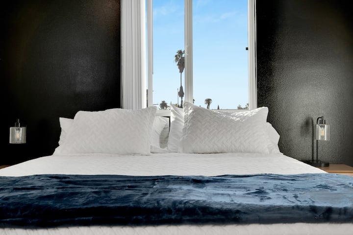 Detta sovrum låter dig njuta av utrymmet och komforten i en king size-säng, stort fönster och en svart accentvägg.