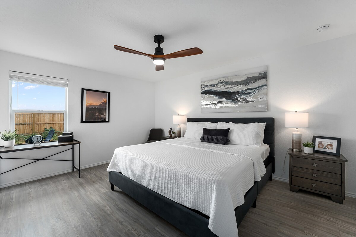 Manželská posteľ v spálni s vlastnou kúpeľňou, priestorom na písací stôl a výhľadom na dvor.