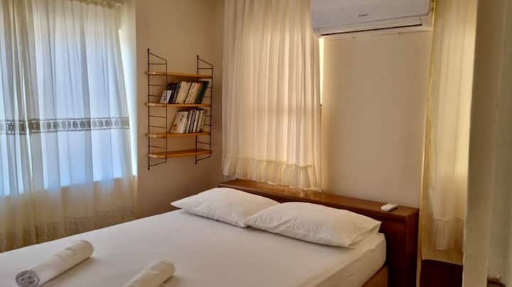 El primer dormitorio de arriba no solo ofrece aire acondicionado, un escritorio para trabajar, un armario y libros, sino que también cuenta con un balcón donde puedes disfrutar del aire fresco y relajarte.